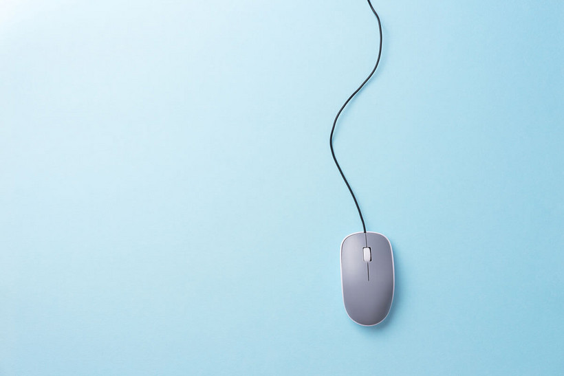 Auf dem Bild sieht man eine Computer Maus mit Kabel vor einem blauen Hintergrund
