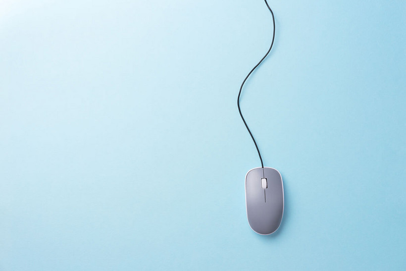 Die 3 größten Fehler am digitalen Arbeitsplatz - und wie man sie vermeidet - Eine Computer-Maus auf blauem Hintergrund Auf dem Bild sieht man eine Computer Maus mit Kabel vor einem blauen Hintergrund